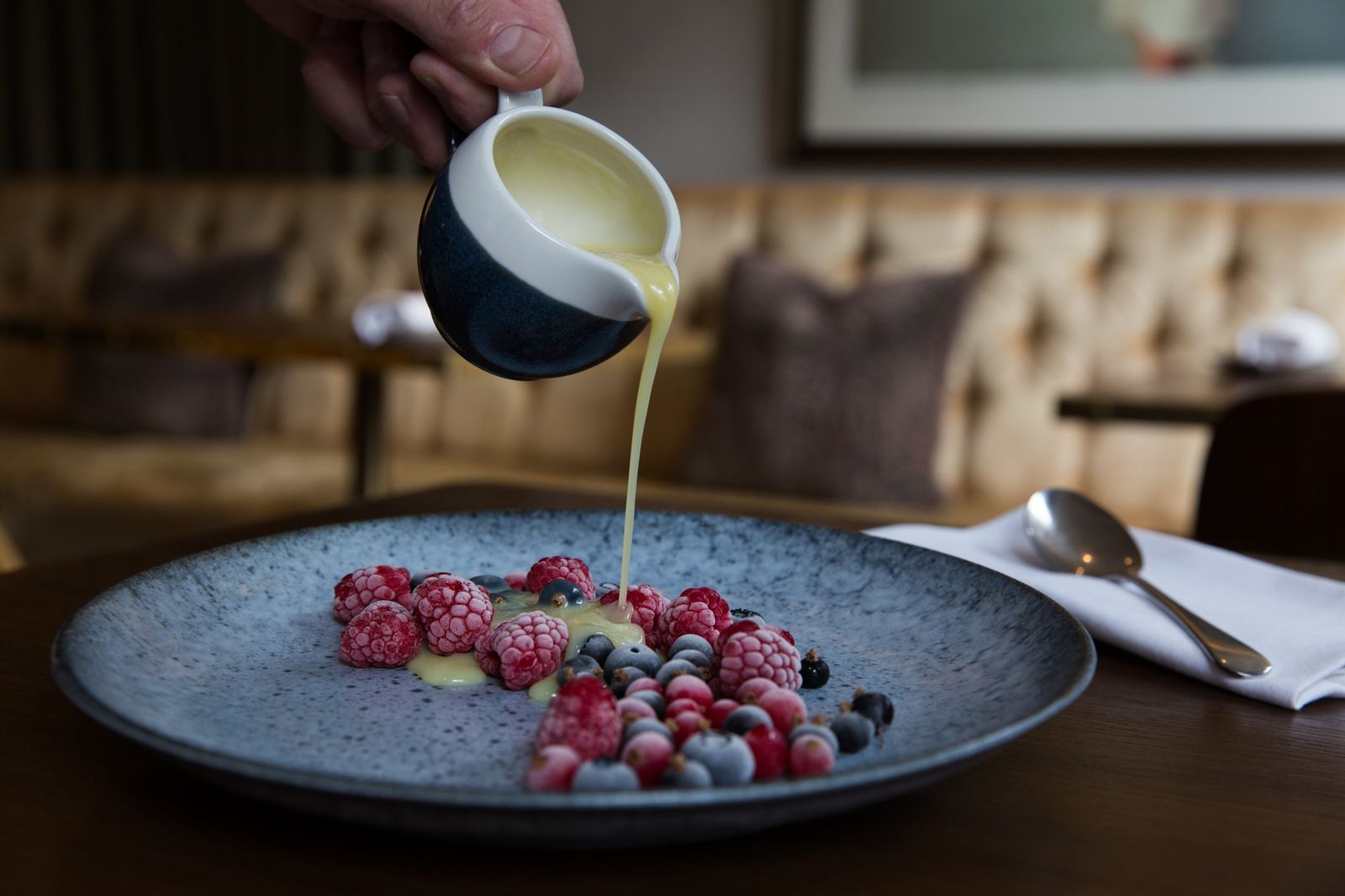 Warm custard poured over frozen berries