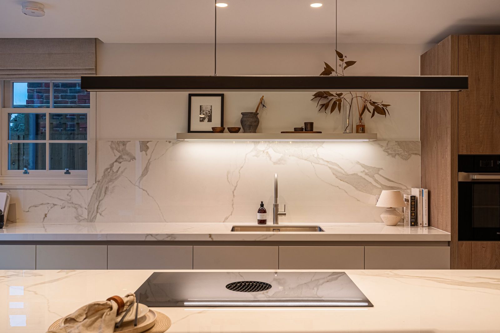 The marble splashback and floating shelf in the kitchen