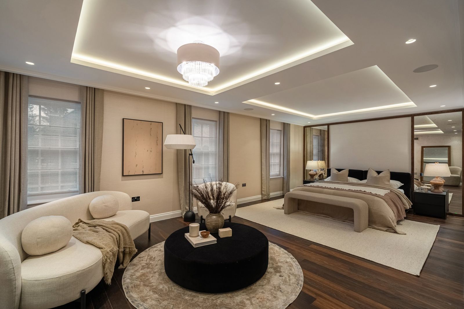 The main bedroom with a seating area and mirrored headboard wall