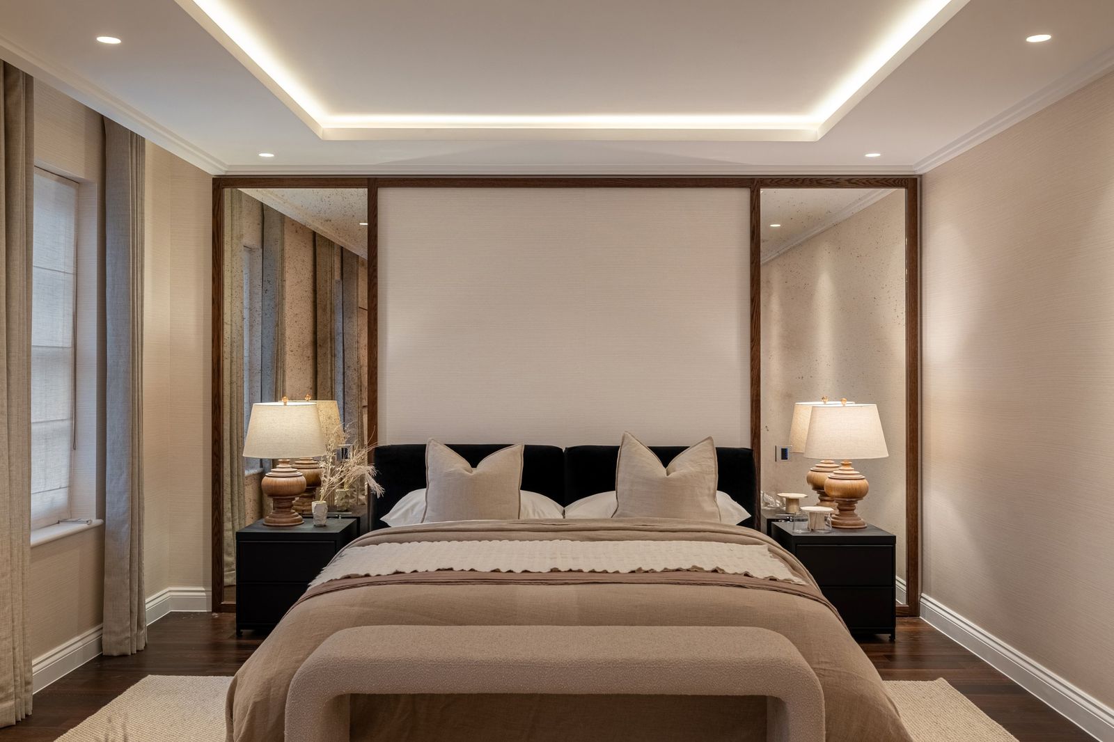 A neatly made bed with matching lamps