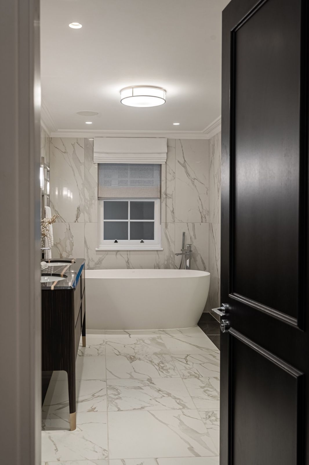 A clean marble bathroom with a freestanding bath
