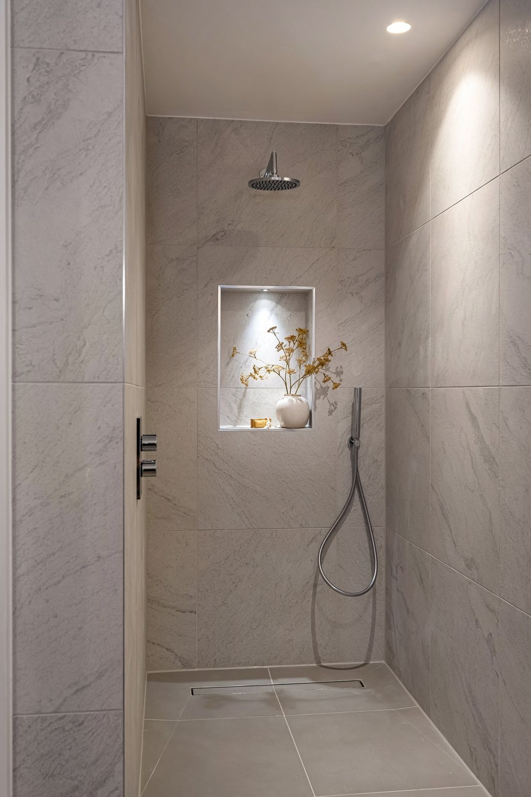 The walk-in shower with a lit niche
