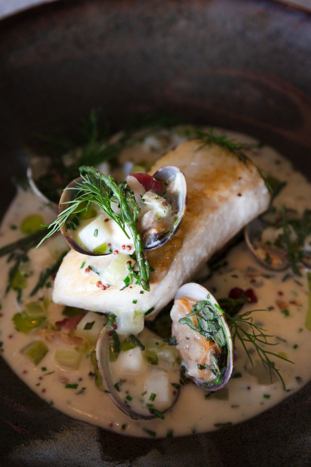 Pan-roasted fish with clams, samphire and dill in a creamy broth
