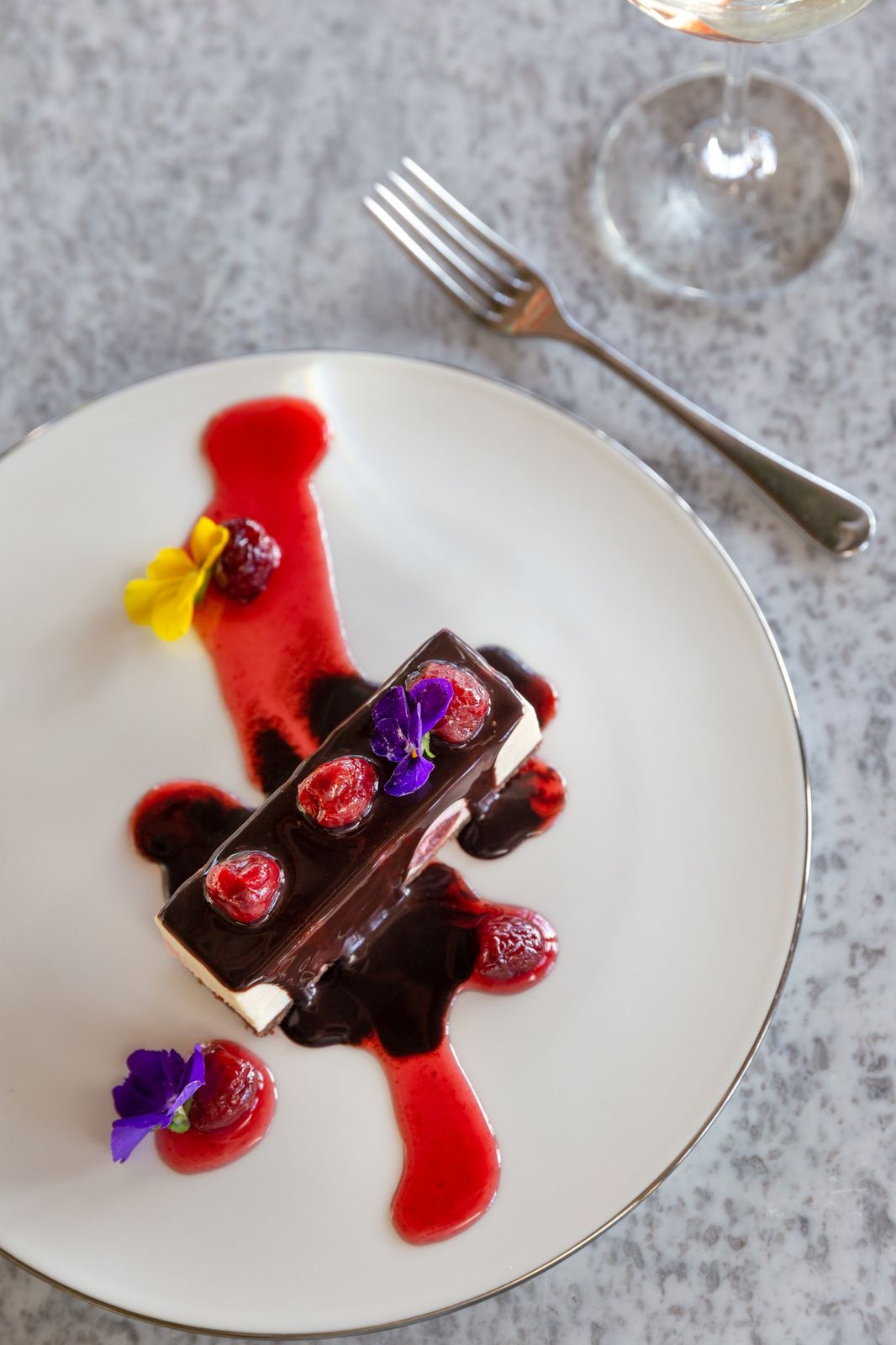 A chocolate and cherry dessert with edible flowers