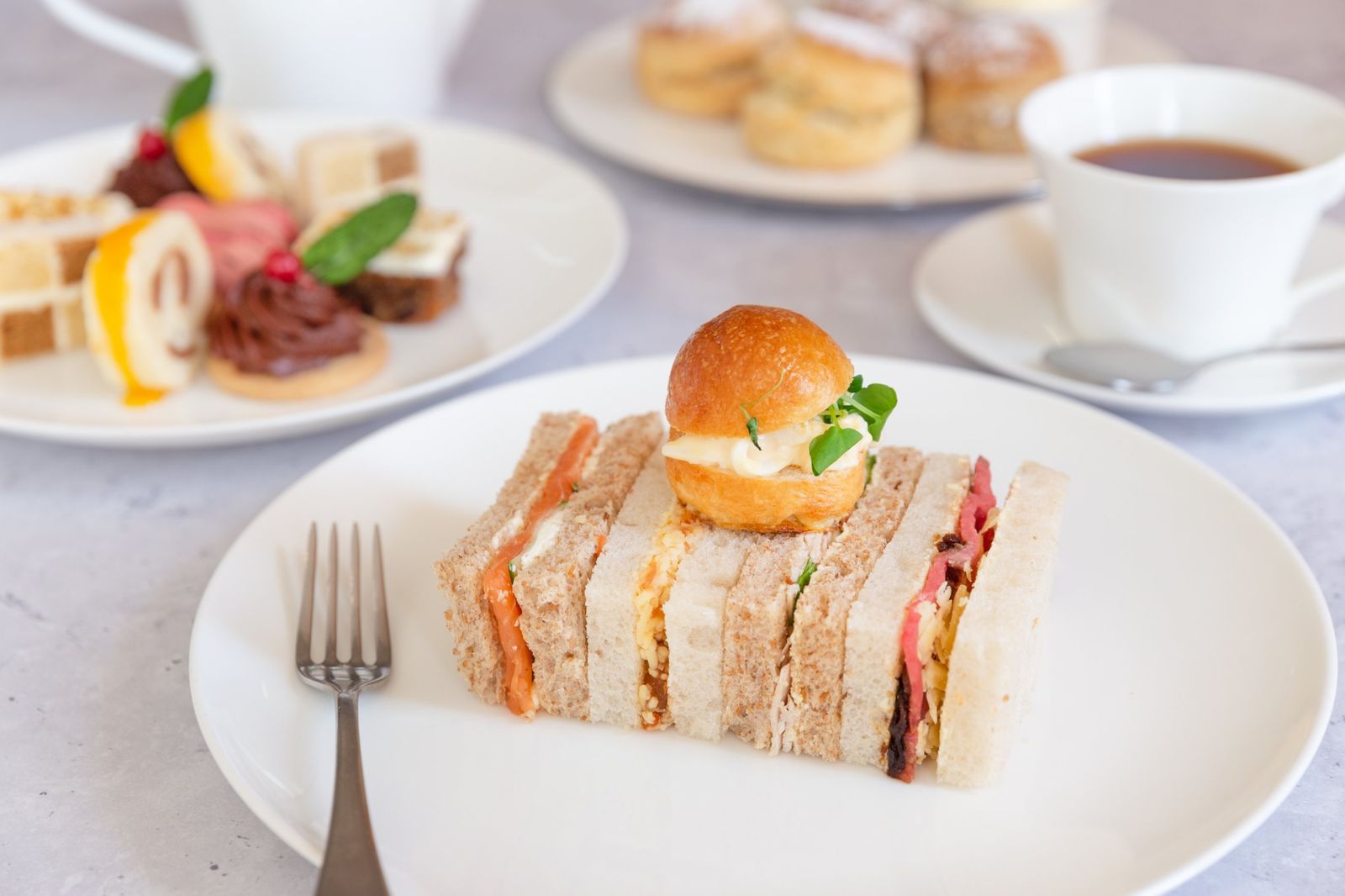 Finger sandwiches and a brioche bun for afternoon tea