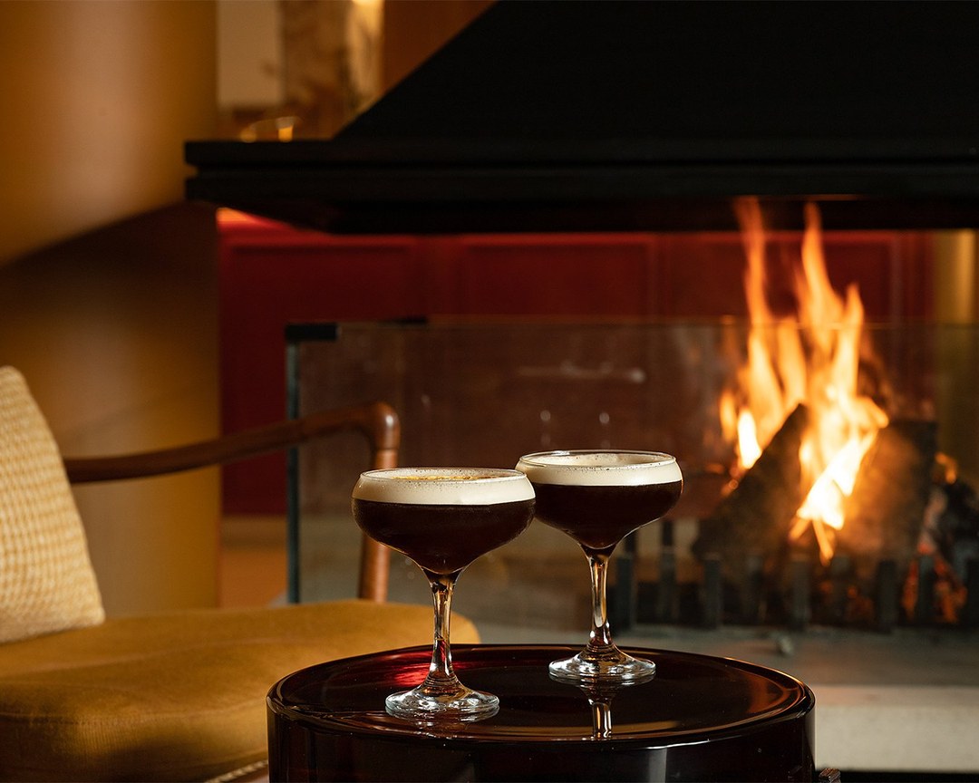 Two espresso martinis in front of an open fire