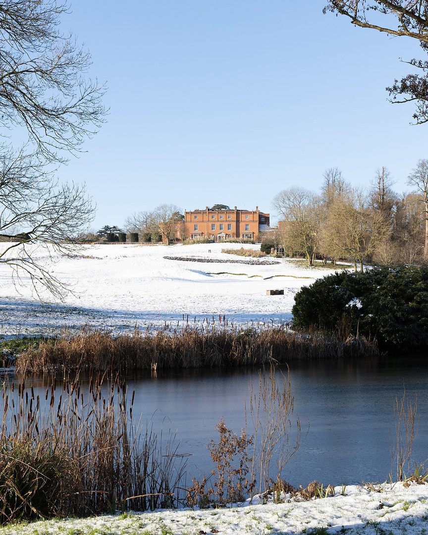 The mansion house across a frozen lake in the snow