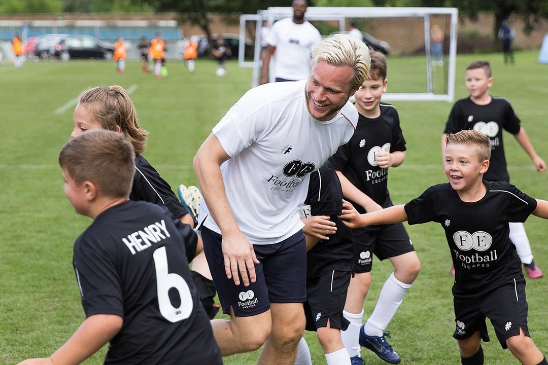 A coach running drills with young footballers