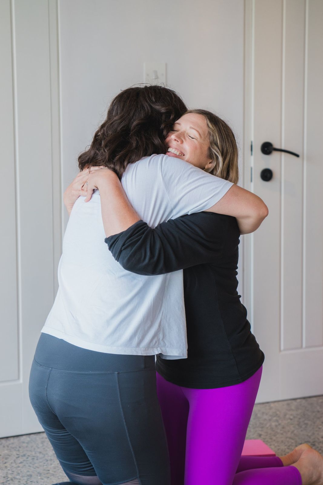 Two guests sharing a hug after class