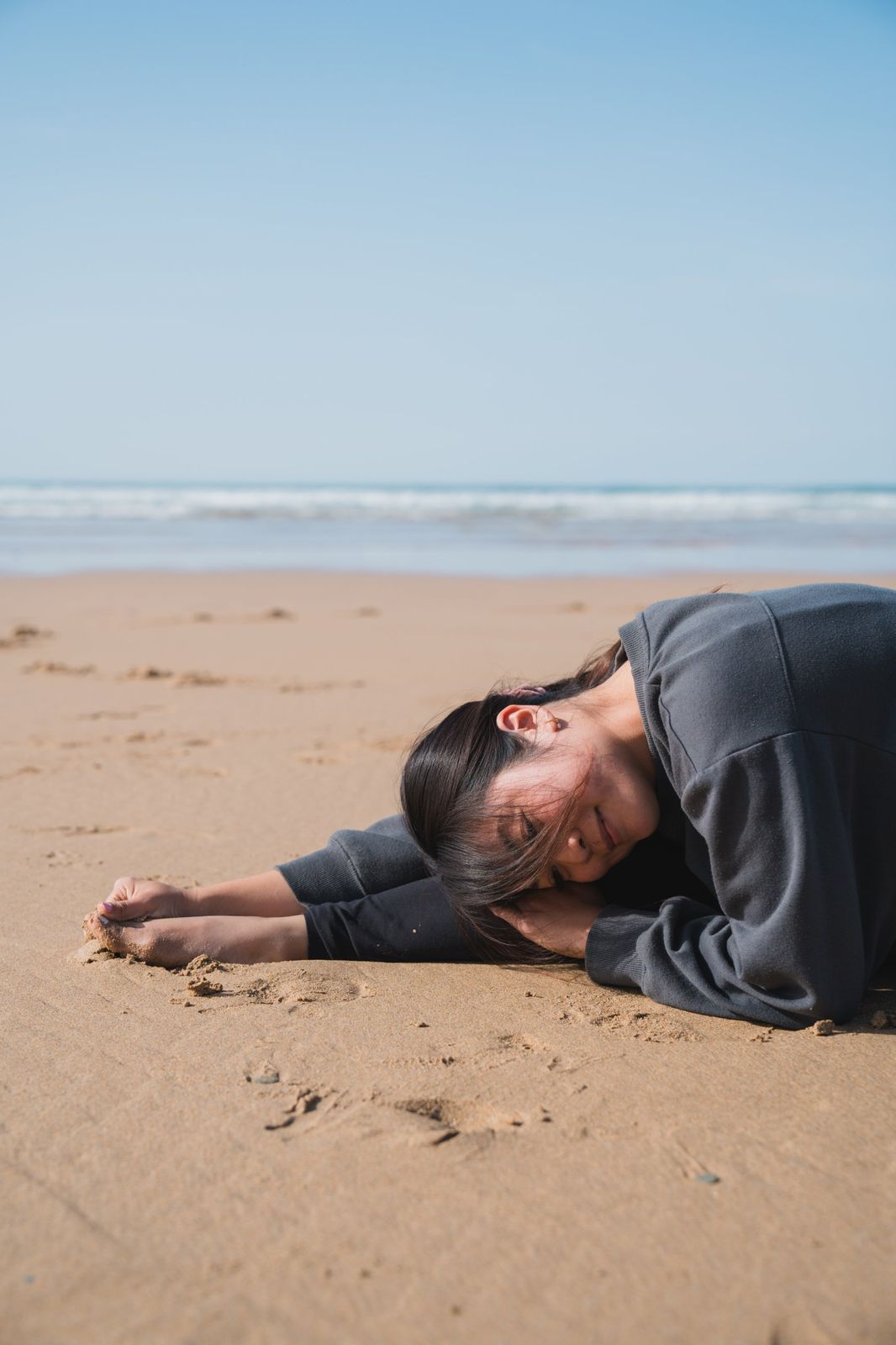 The host resting on the sand by the sea