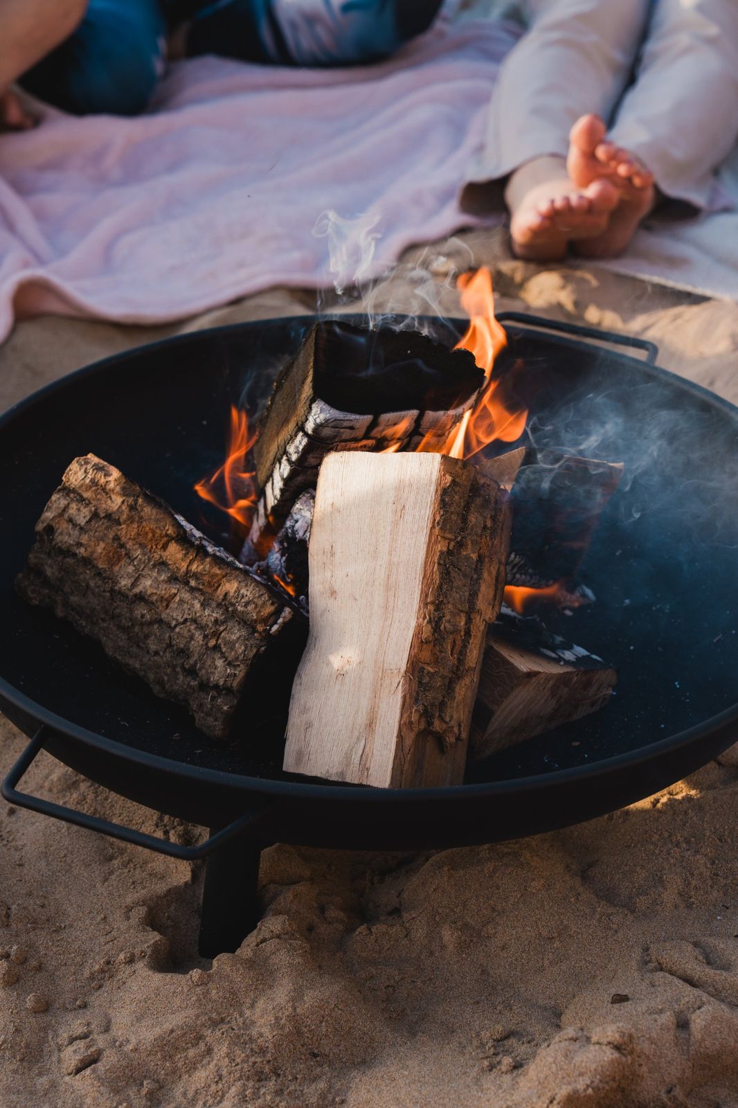 A fire pit burning on the sand