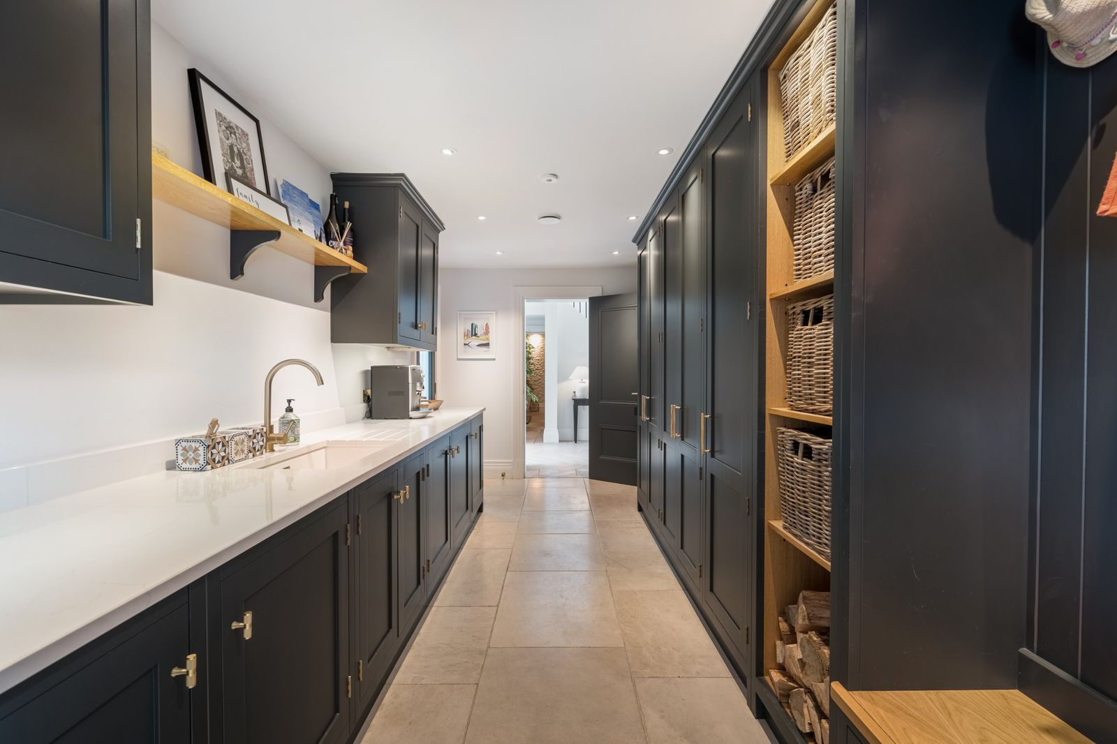 The boot room with dark cabinetry and log store
