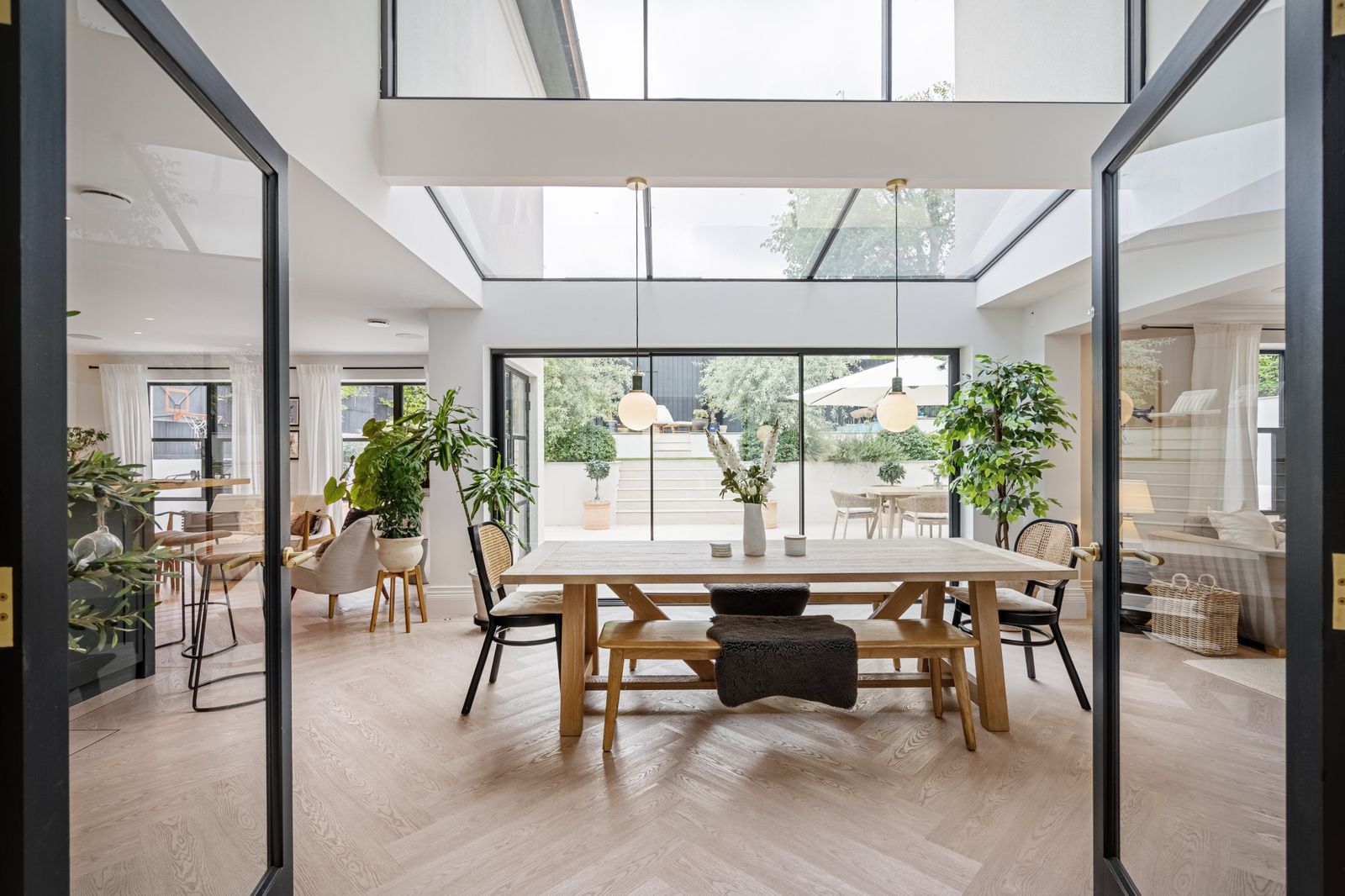 The dining room under the roof glass, seen through glazed doors