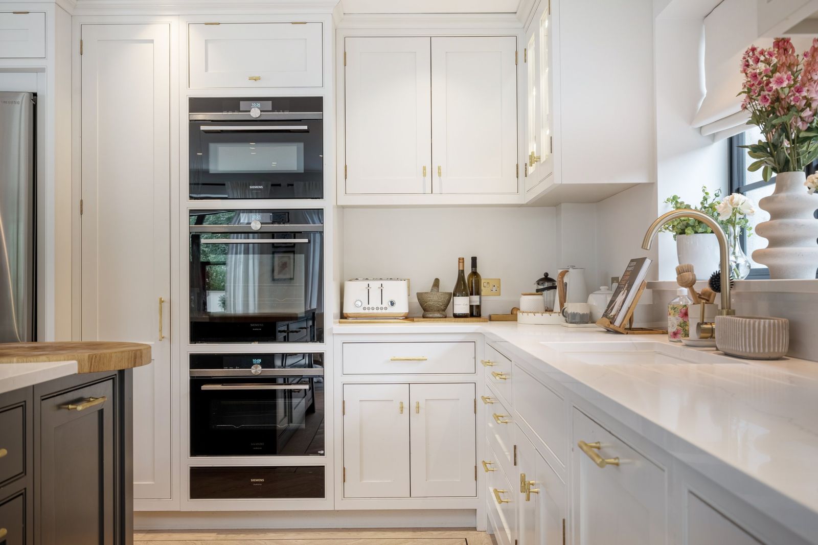 Built-in ovens and white shaker cabinets in the kitchen