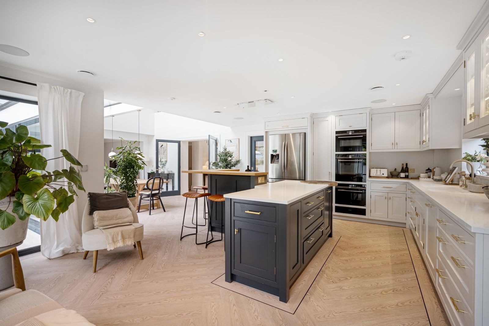 The kitchen with a dark island and herringbone floor