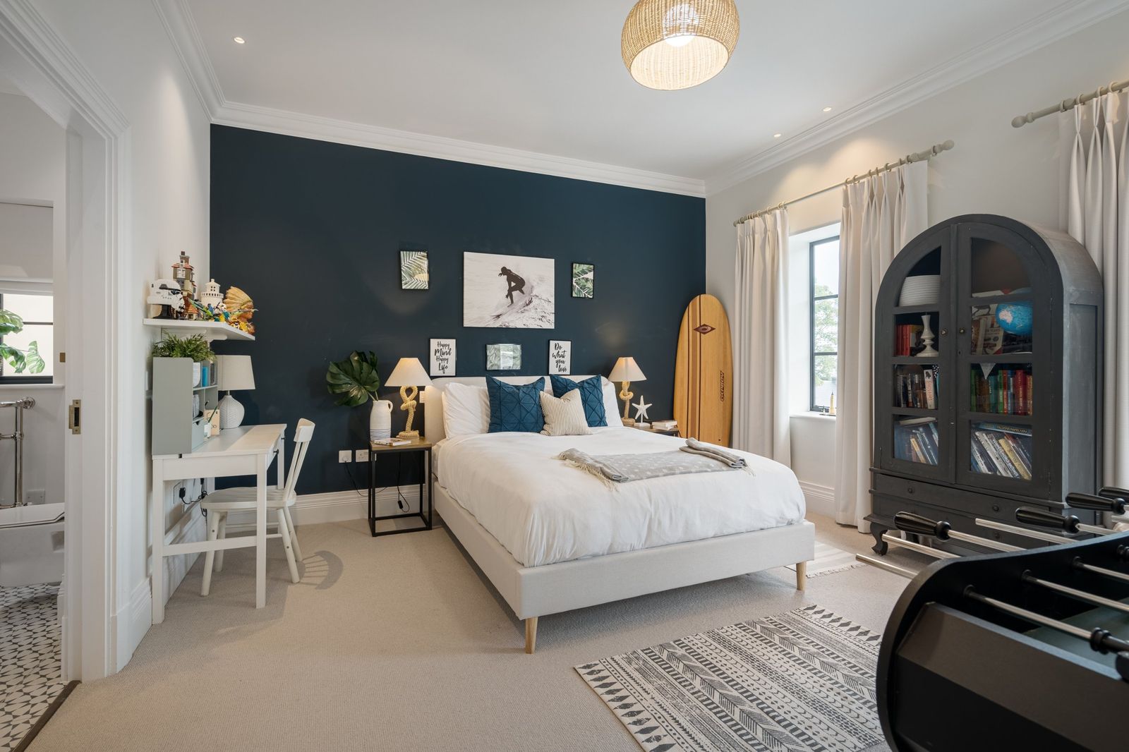 A surf-themed bedroom with a navy feature wall