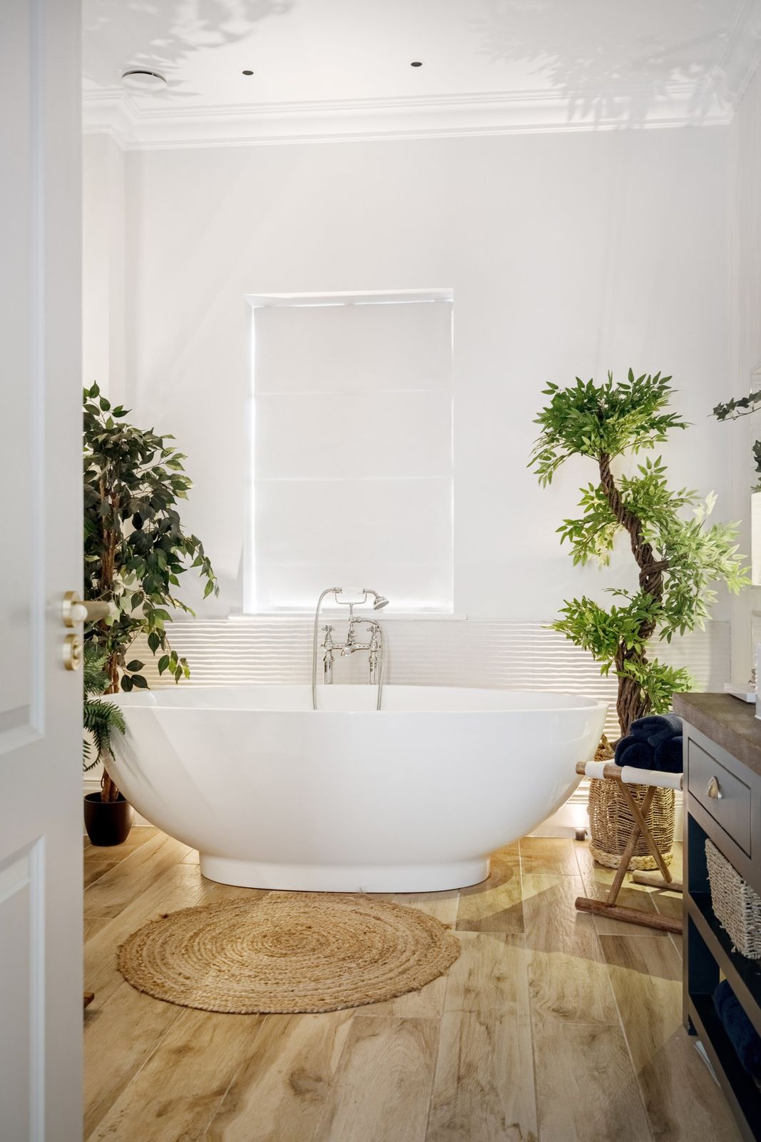 The freestanding bath framed by plants