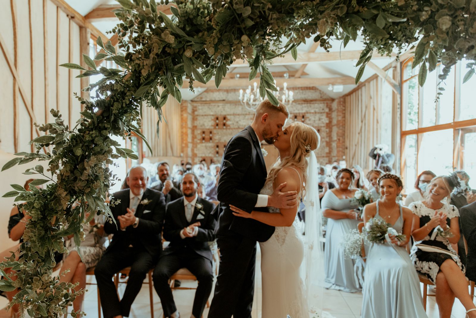 The couple's first kiss as guests cheer