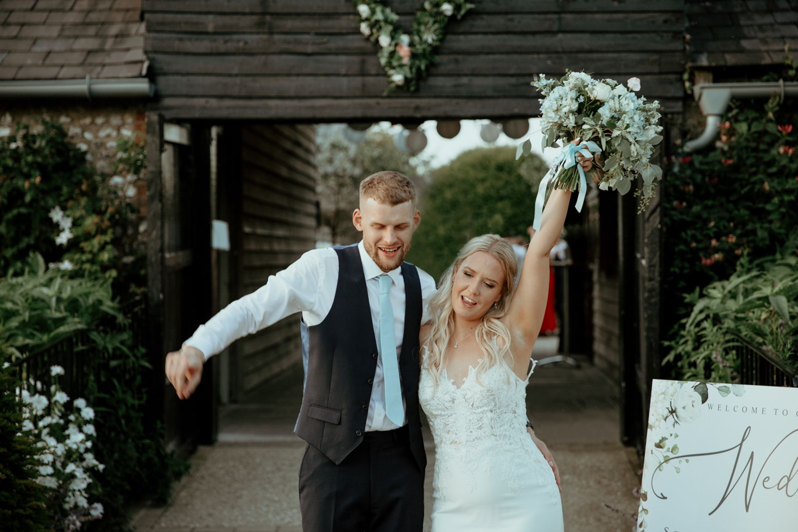 The newlyweds celebrating, bouquet in the air