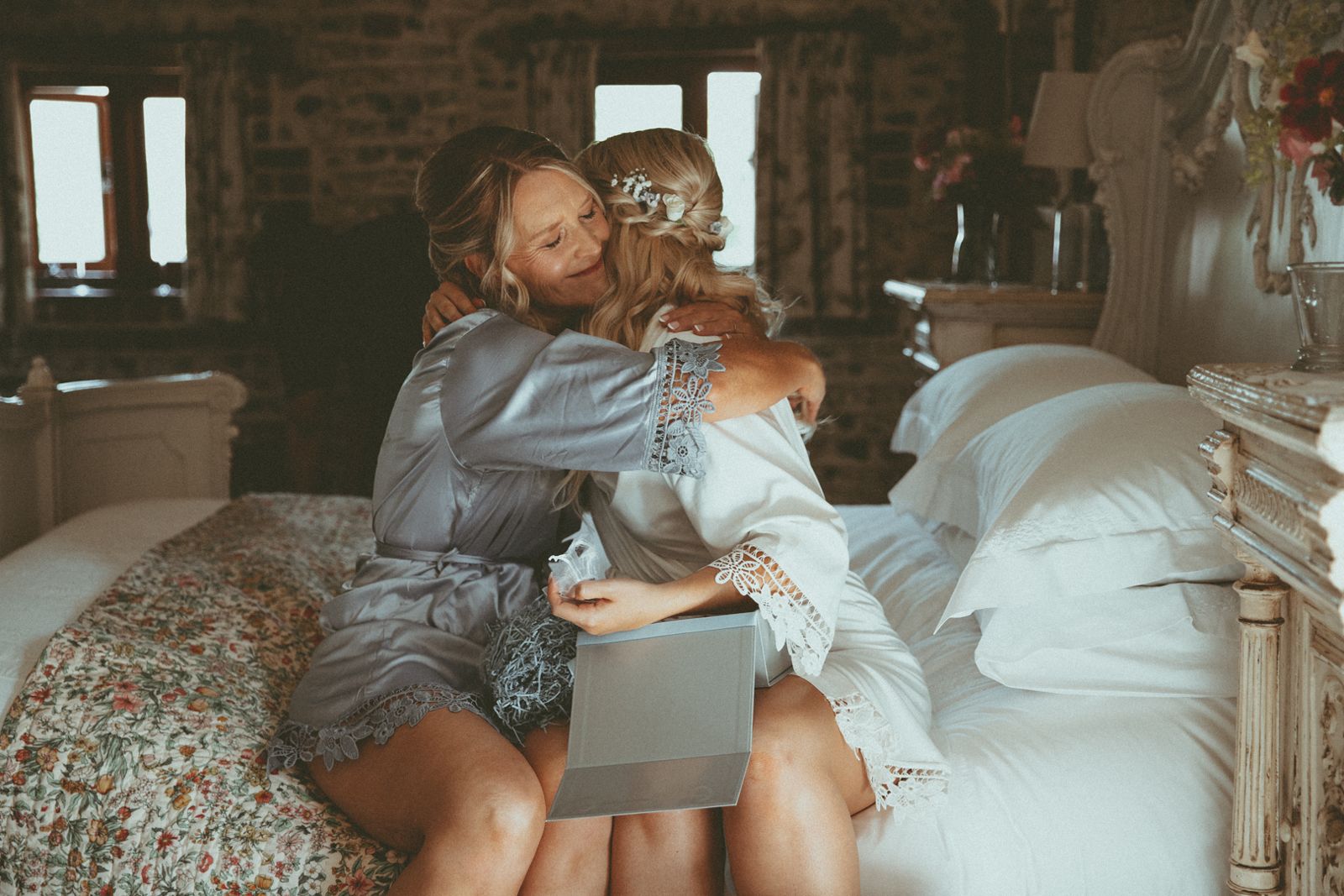 A bride and her mum hugging while getting ready